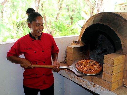 chef pulling pizza from pizza oven