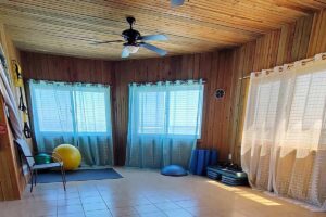 Wellness Center Bright yoga room at Clark's Cay Guanaja with wooden walls and large windows.